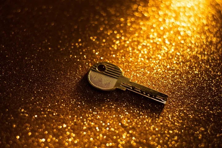 Golden key on dark background