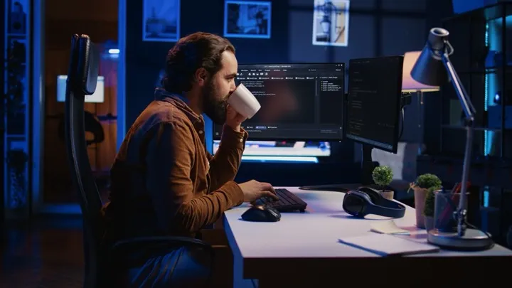 Developer focused at workspace with coffee